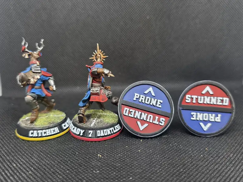 A catcher and a knight beside two prone and stunned underside discs