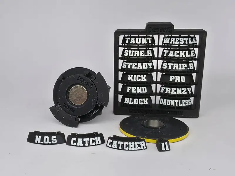 Close-up of a base underside showing the magnet, with loose skill tags and a sprue