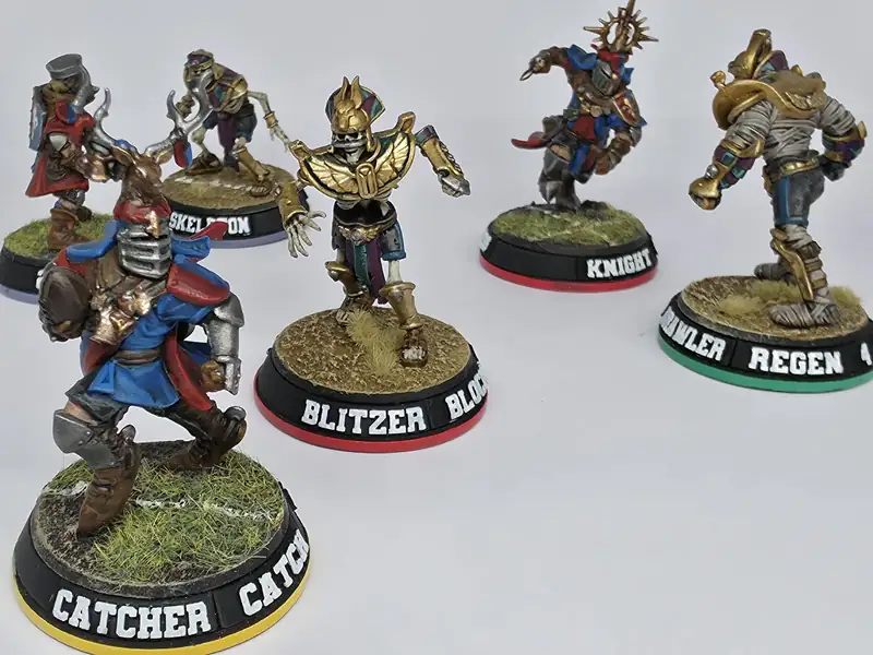 Five painted miniatures on colour-rimmed Blitz Bases