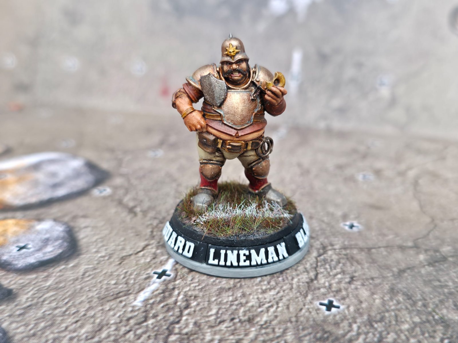 A painted Lineman miniature on a Blitz Base showing positional and skill tags
